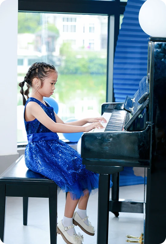KLIS student playing the grand piano at the Music & Art Festival