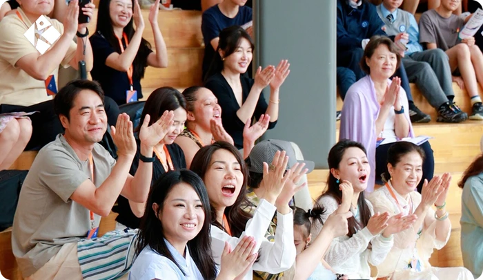 Parents and students applauding during the KLIS Music & Art Festival