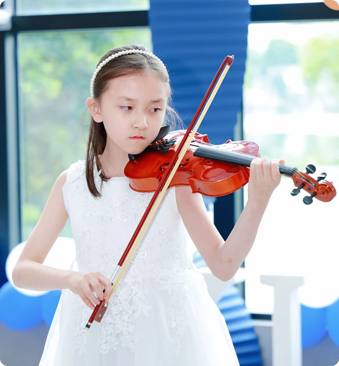 KLIS student playing the violin on stage at the KLIS Music & Art Festival