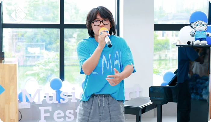 KLIS student singing with a microphone at the KLIS Music & Art Festival concert