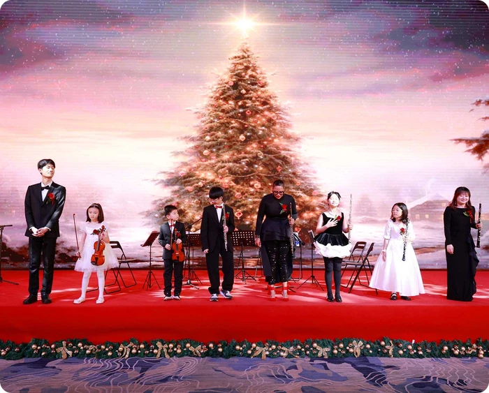 KLIS Christmas concert ensemble on stage with students in formal performance attire