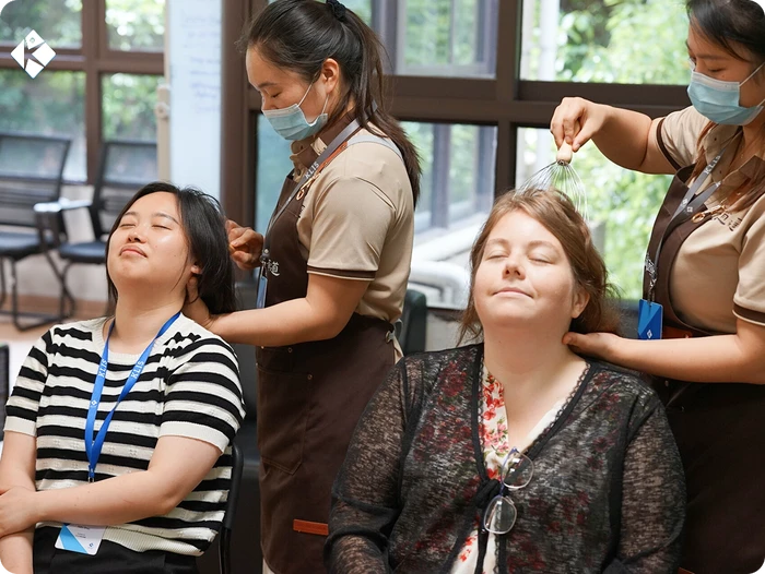 PTA volunteers giving relaxing head massages to KLIS teachers on Dress-Up & Pampering Day
